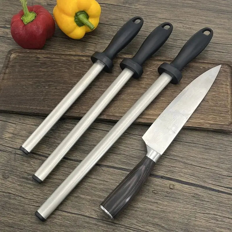 Une-vue-en-plongee-de-trois-fusils-a-aiguiser-servant-d_affuteur-de-couteau-professionnel-poses-en-diagonale-a-cote-d_un-grand-couteau-de-cuisine_21df6490-956f-4201-8a92-29b47c8d56c1